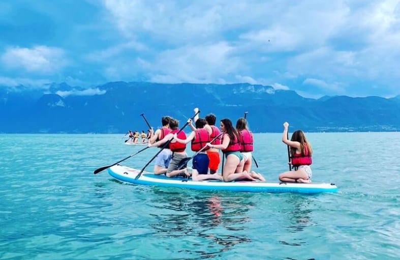 teenagers on Lake Geneva doing paddle boarding