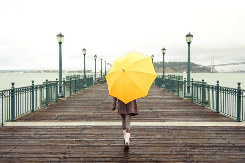 Vibrant atmosphere at San Francisco Pier with a teenager walking on the Golden Gate Bridge in the distance, capturing the essence of San Francisco's lively waterfront
