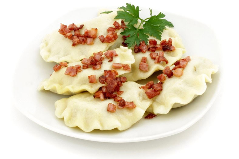 Pierogi is a Polish dumpling that is filled with meat, cabbage and potqaot or with fuits. The are either steamed likein this picture or steamed and then fried in a pan. Steamed Pierogi is usually garnished with some bacon and coriander. Pierogi is the best Polish food to try