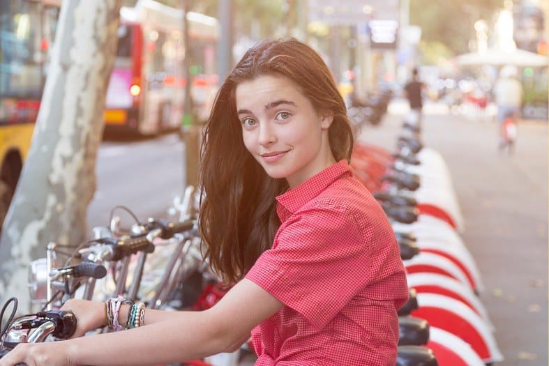a pretty girl grabbing a bike in Barcelona