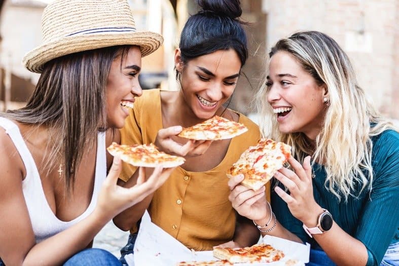 A moment of pure enjoyment as a group of teenagers savor delicious pizza in Rome