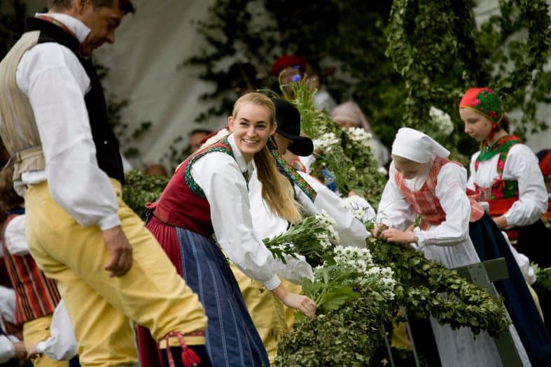 people dressed in traditional clothes in stockholm during a celebration at the Skansen