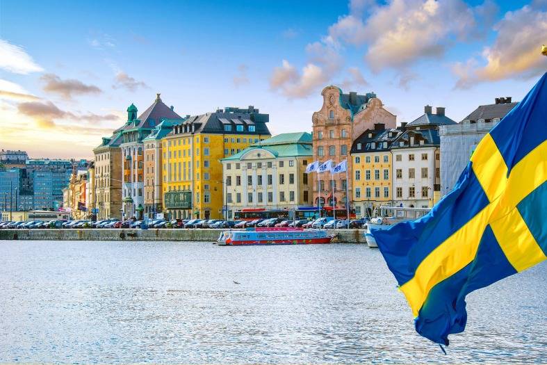 A boat on the water in Stockholm showing the flag of Sweden