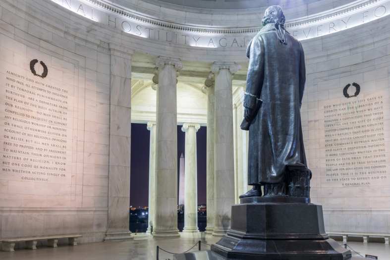 a statue of a man in a robe in front of Jefferson Memorial