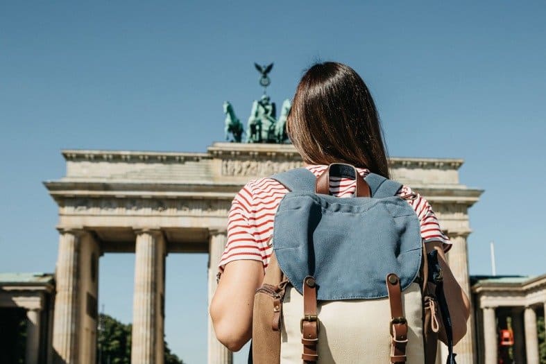 A teenage girl standing near the Brandenburg Gate in Berlin