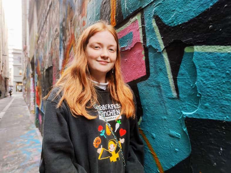 A teenage girl in melbourne checking out street art in a laneway
