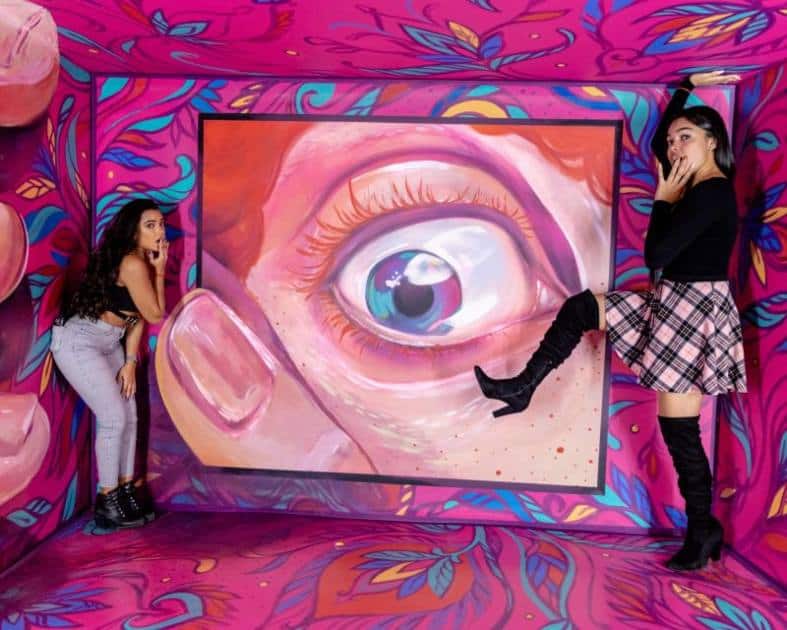 two teenage girls having fun with illuusions at a museum in Miami