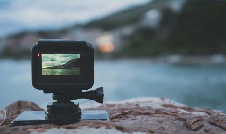 A samll action camera situated on some rocks