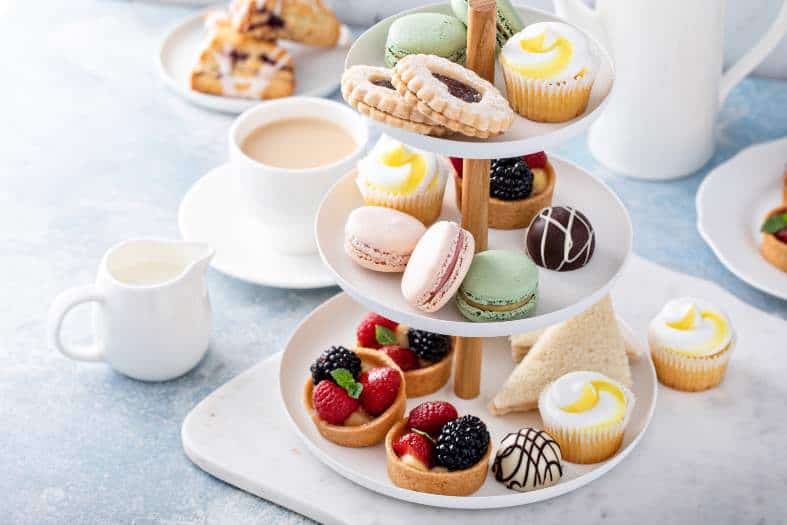 an afternoon tea settting with cakes and sandwiches