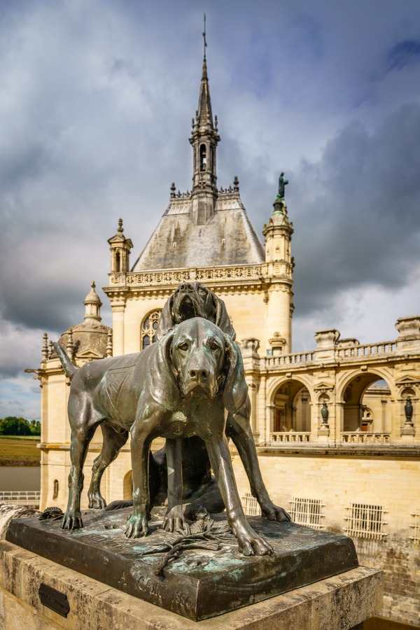 a castle at chantilly in France with a stature out front