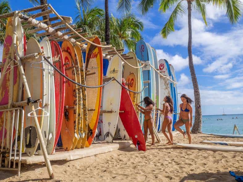 Girls in Hawaii picking out surf boards