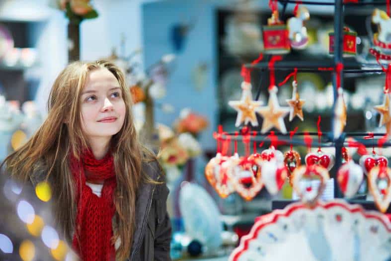 A young teenage girl looking at Christmas gifts at a market in Europe