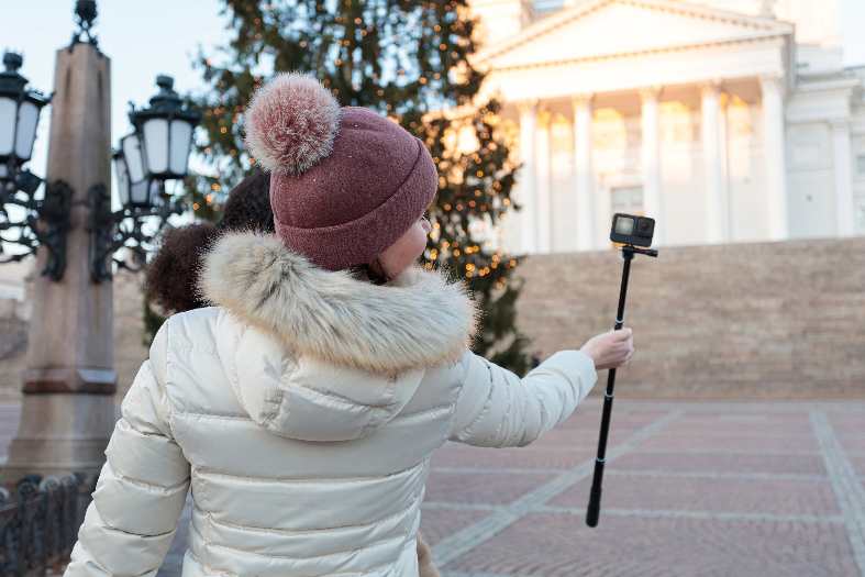 a teenage girl in Senate square taking pictures with her gopro in helsinki