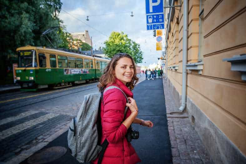 a young adult girl catching a tram in helsinki