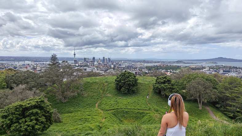 a teenager sitting on the boardwalk at the top of Mount Eden in Auckland