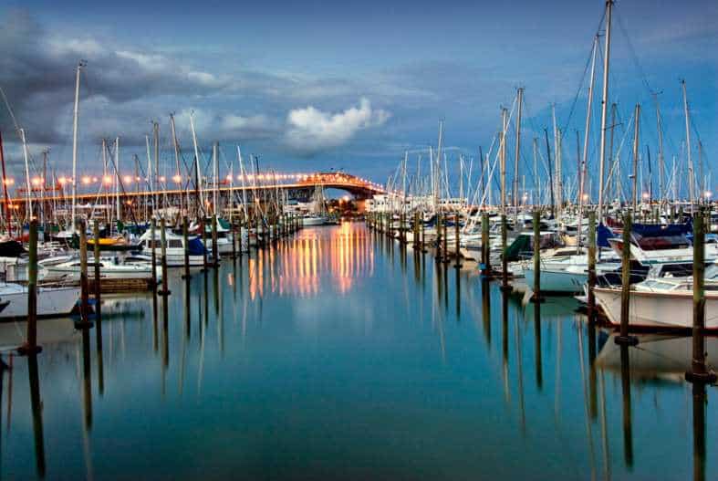 Boats moored at the marina at sunset with water reflection and sunset