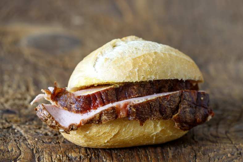 Leberkäse in a bread roll, a type of meatloaf popular in Austria and Germany for those looking for the best street food in Europe.