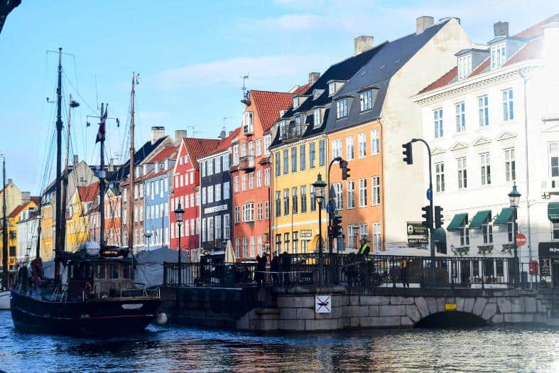 Nyhavn waterfront in Copenhagen, a picturesque scene with colorful buildings, boats, and a vibrant atmosphere