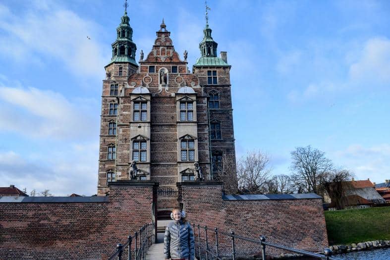 A young teenage girl standing out the front of Rosenborg Castle