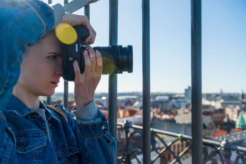 A young adult female taking pictures of Copenhagen from an elevated position