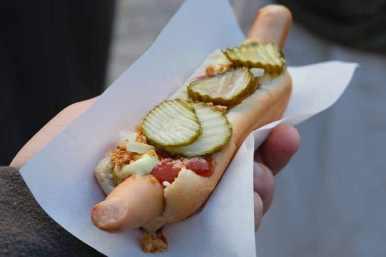 eating hotdog in Copenhagen, filled with onions and pickles