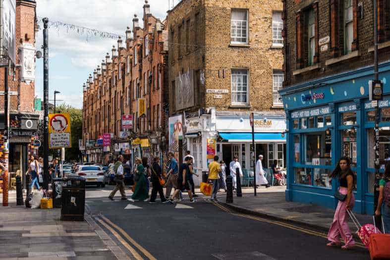 a picture of a street in London with people out shopping