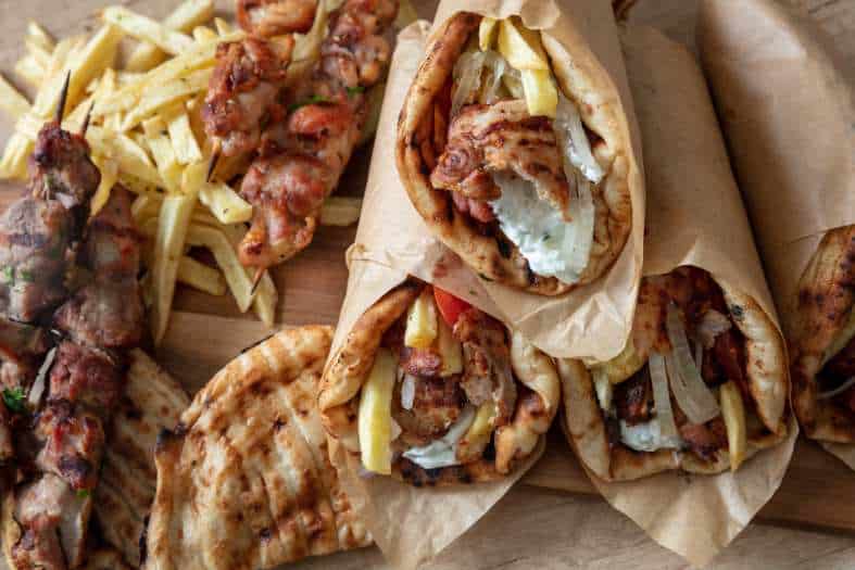 a wrap filled with lamb, onion, lettuce and garlic sauce