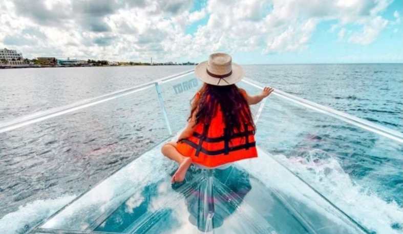 a teenage girl at the front of a glass bottom boat in cancun