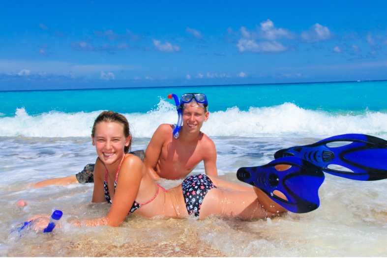 two teenagers in cancun who have been snorkelling now lying on the beach