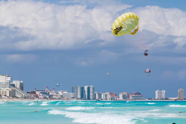 People enjoying parasailing in Cancun Mexico
