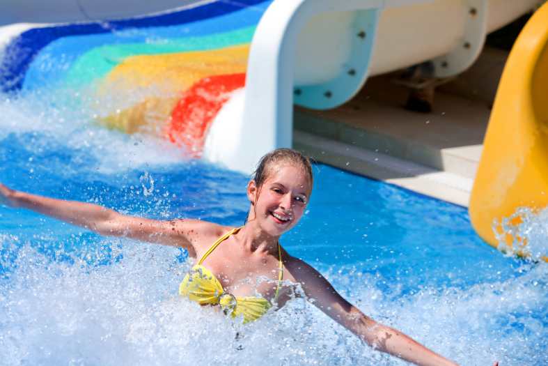 a teenage girl having fun at a waterpark on waterslides