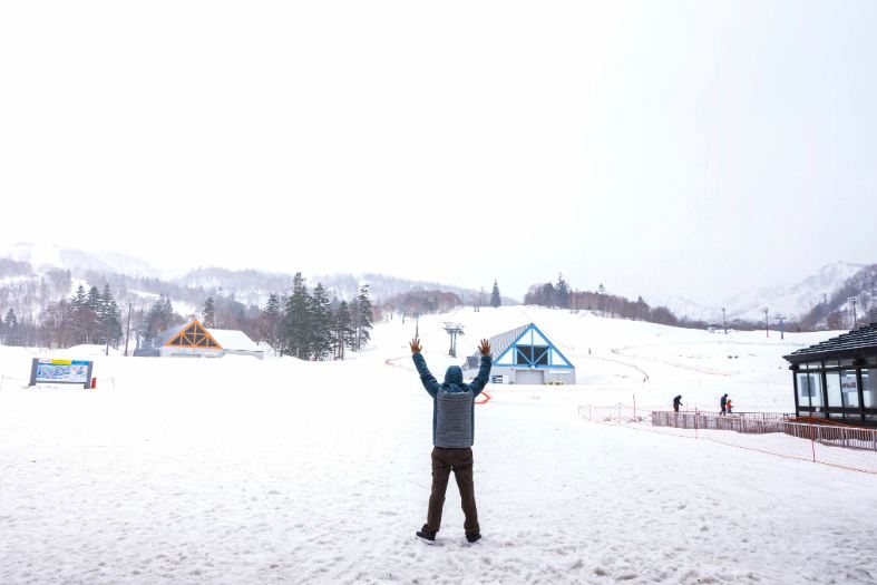 a young adult standing in the snow in Japan