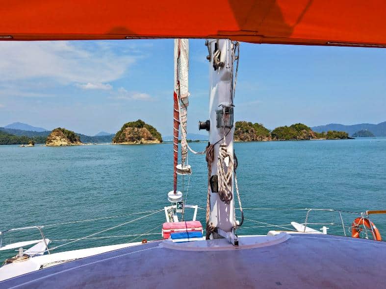 the front end of a boat that is cruisng the waters off langkawi