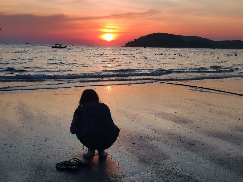 a teenage girl taking pictures of the sunset in Langkawi