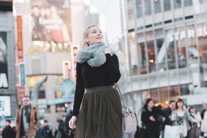 Young adults exploring Tokyo, with bustling streets, bright neon lights, and a lively atmosphere showcasing the dynamic energy of the city