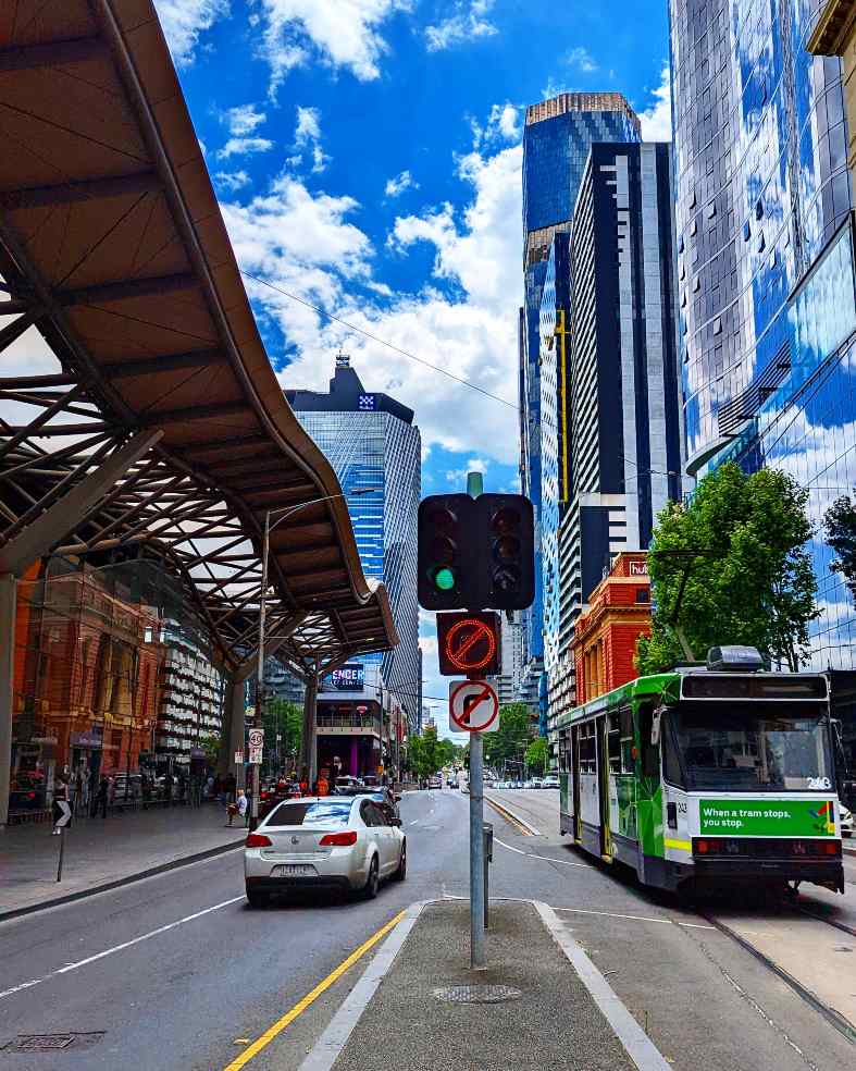 a melbourne tram sharing the city street with a car