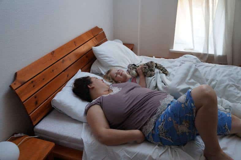 Mother and daughter enjoying morning snuggles. Choosing the best accommodation for families should include everything your family needs