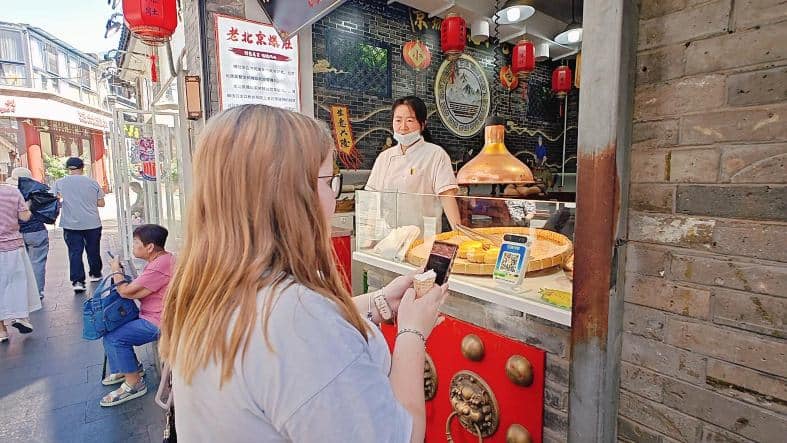 a girl about to scan her alipay code to pay for food in beijing